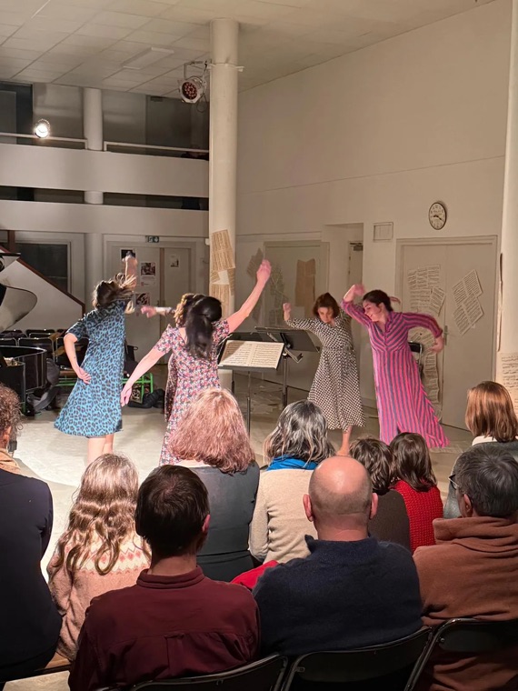 Public assis dans un salon pendant une représentation de danse
