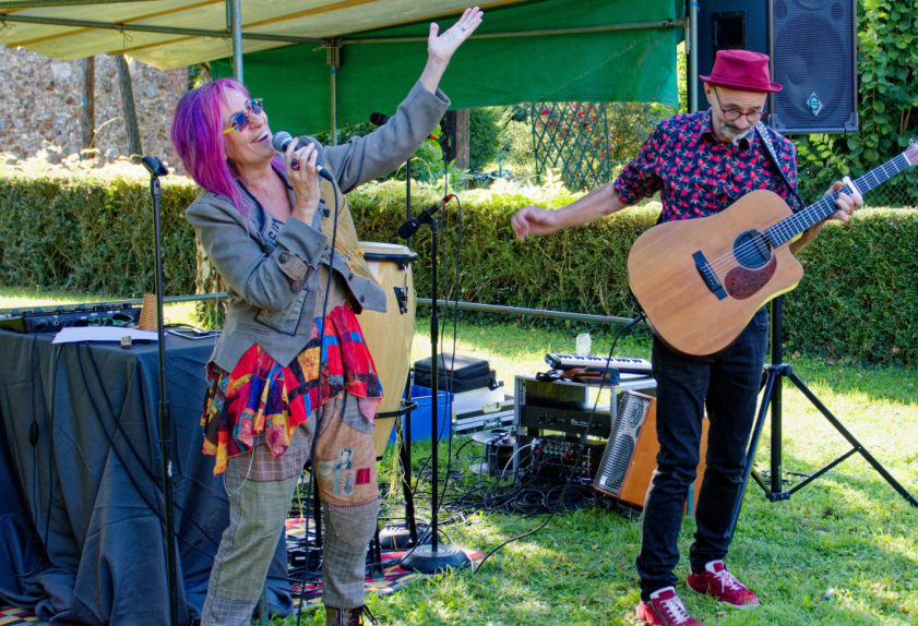 Duo de musiciens jouant sous une tonnelle dans un jardin
